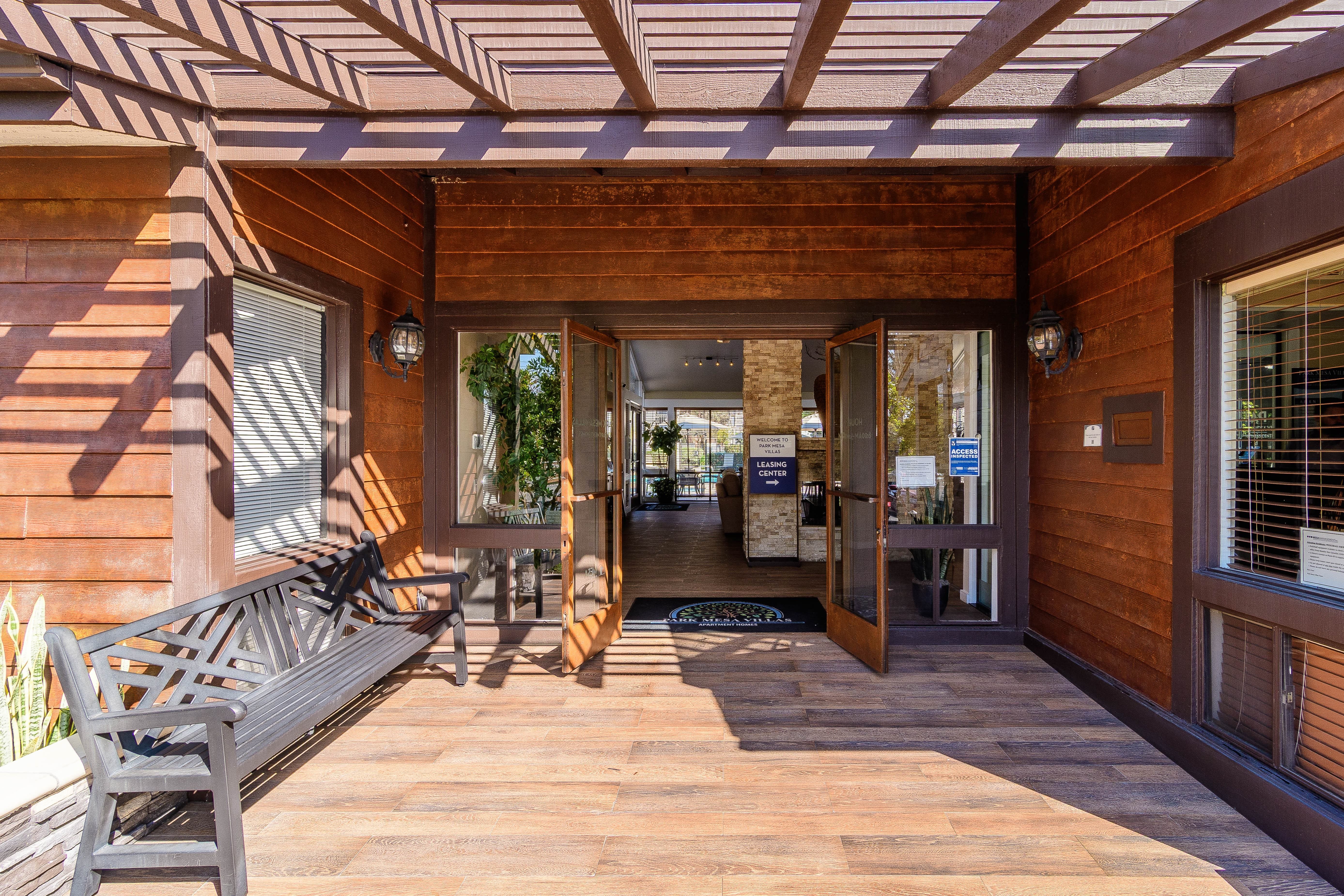 A wooden deck with a bench and a table.